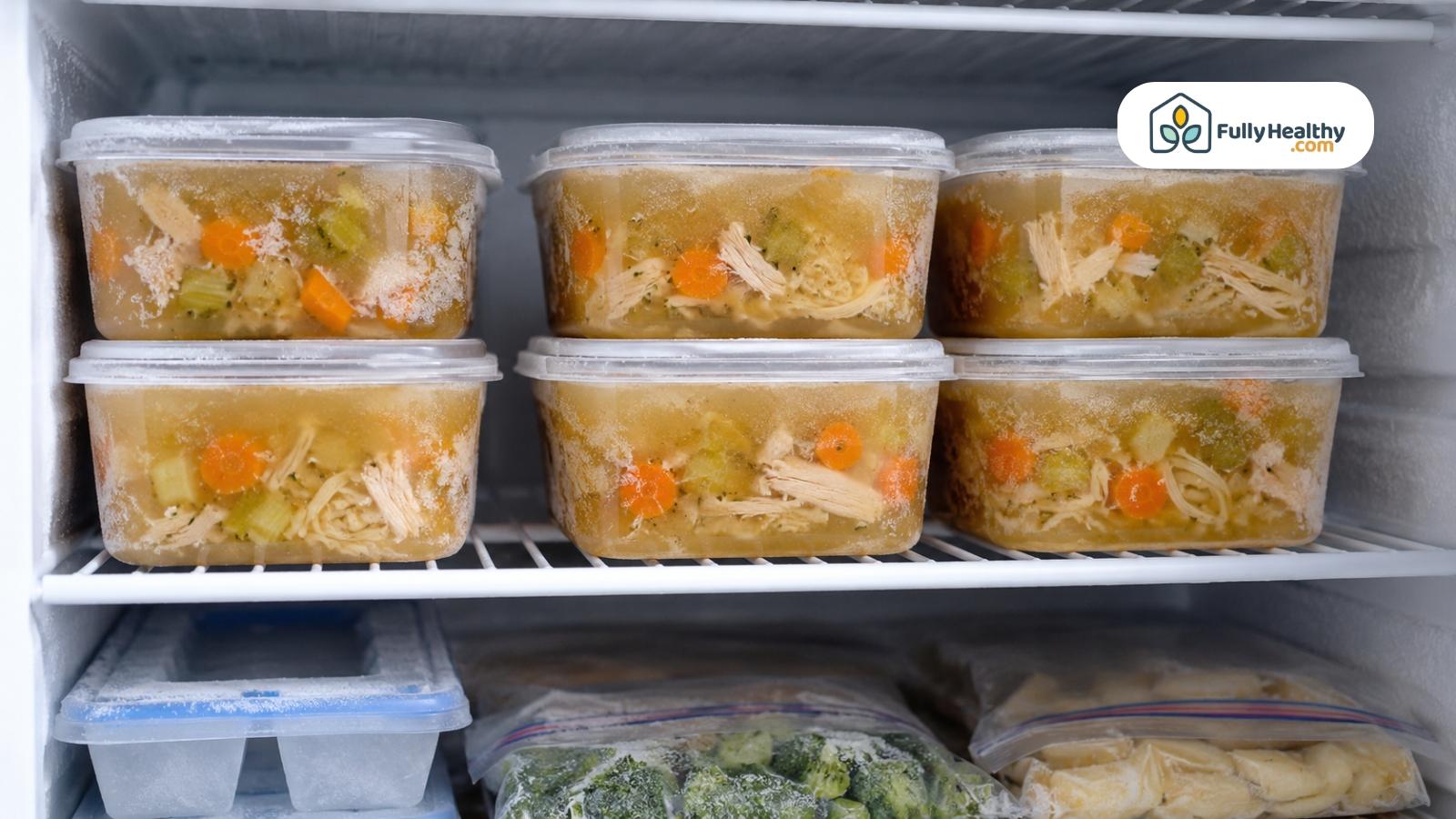 Frozen chicken noodle soup containers neatly stacked on a household freezer shelf