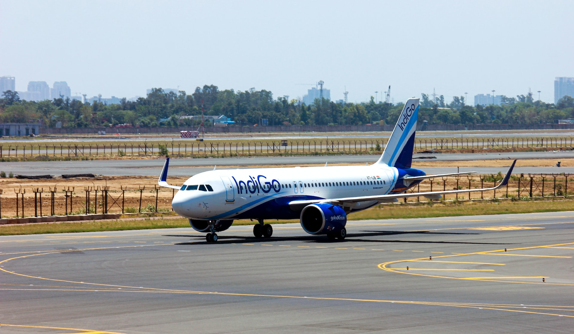 An IndiGo aircraft following hold short lines as it taxies to the runway.