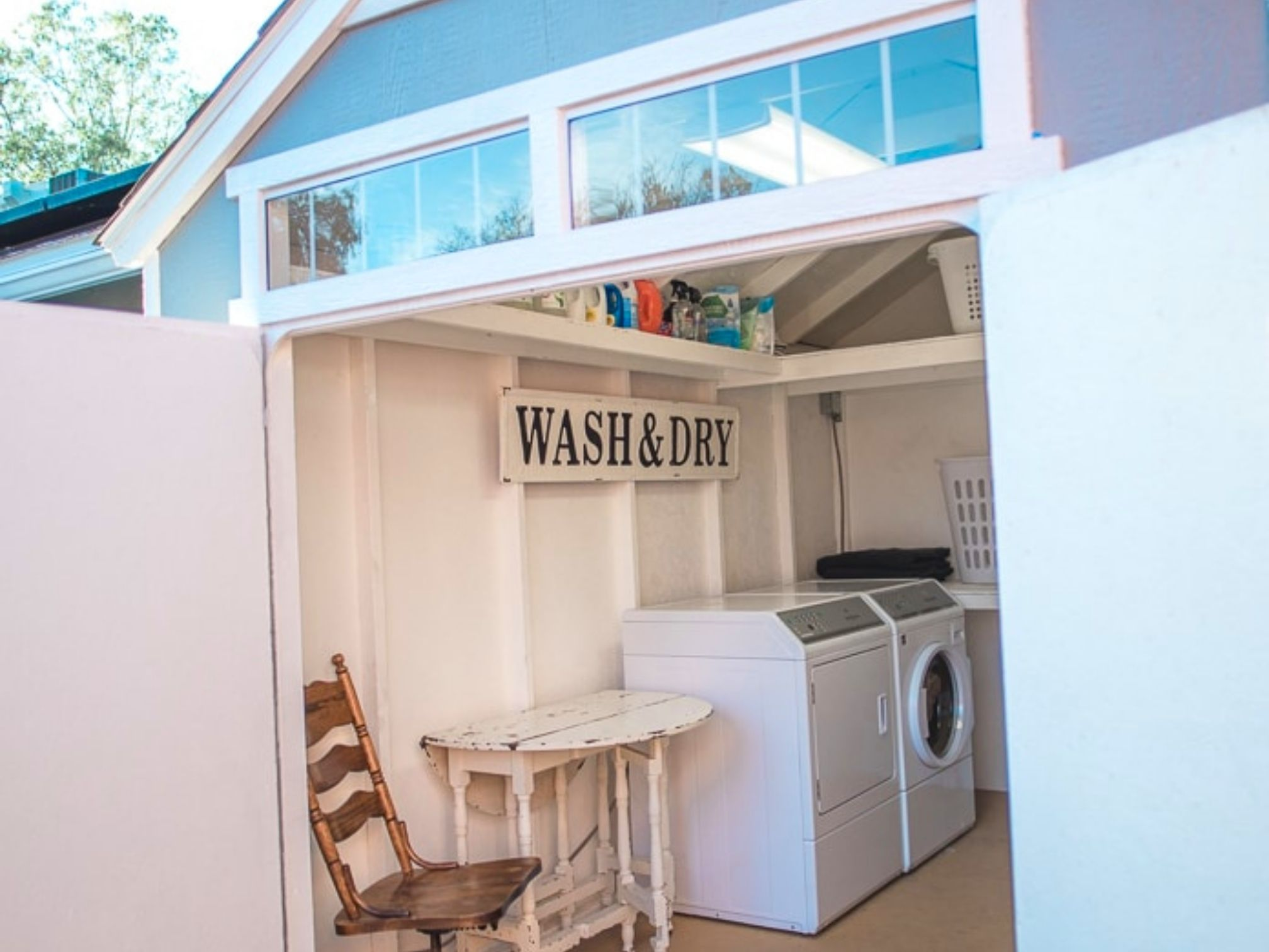 shed laundry room with washer and dryer inside