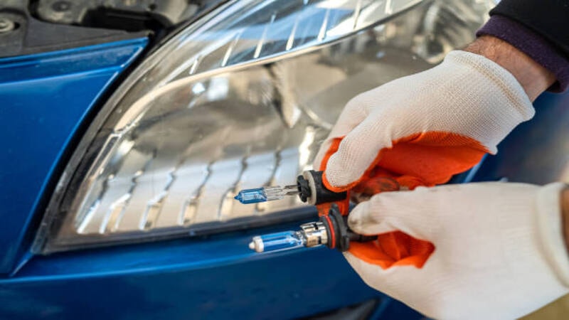 A technician toubleshooting the LED headlights of a car. 