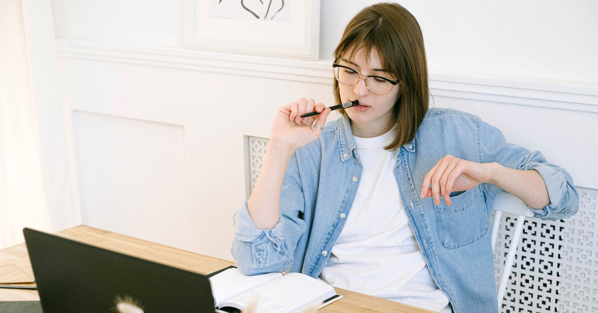 A woman calculating expenses to understand tax breaks for self employed OnlyFans performers.