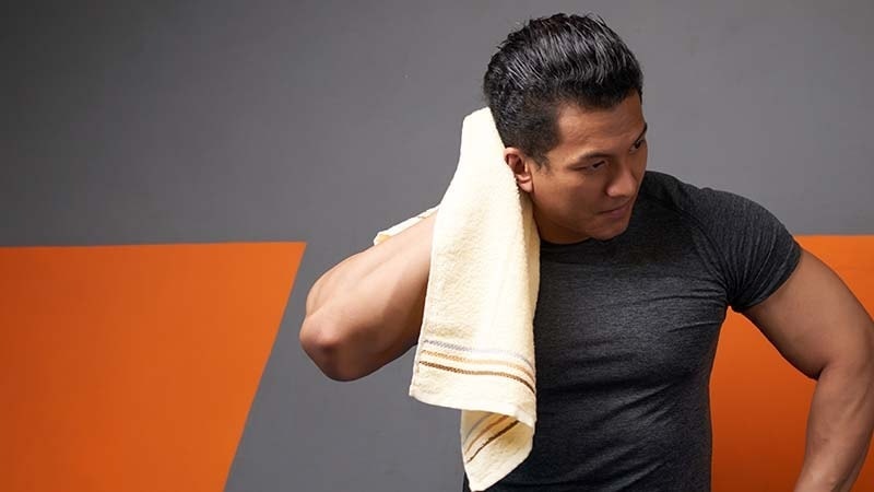 A man using a hand towel after the gym
