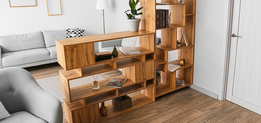 Two wooden open bookshelves are being used as a room divider to separate the main hallway and a living area.