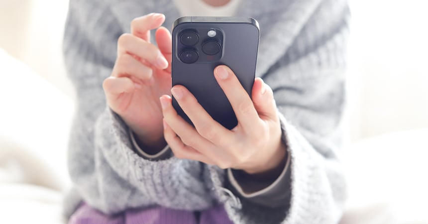 Holding phone wearing a grey sweater