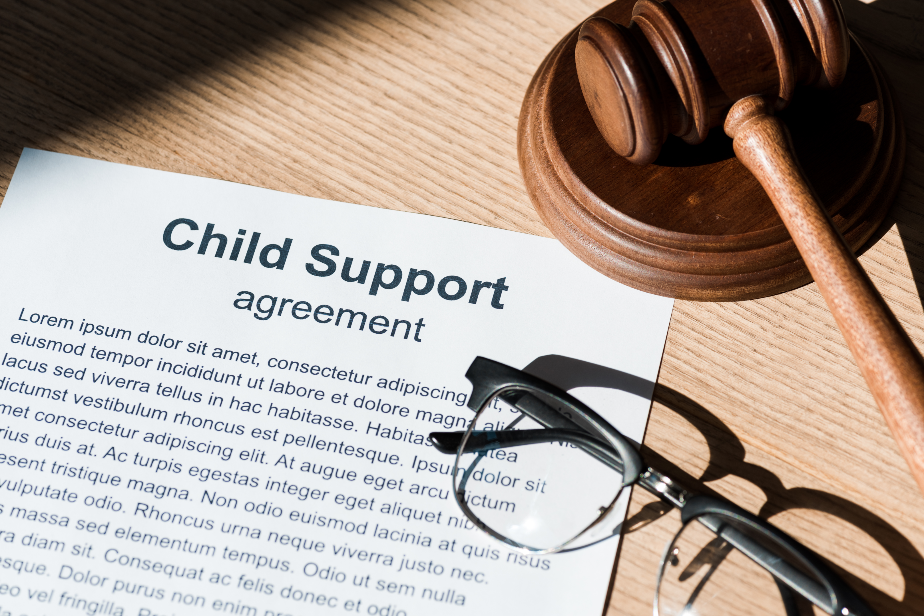 A wooden gavel beside a child support document illustrates the vital role legal agreements play in securing a child's future for unmarried couples.