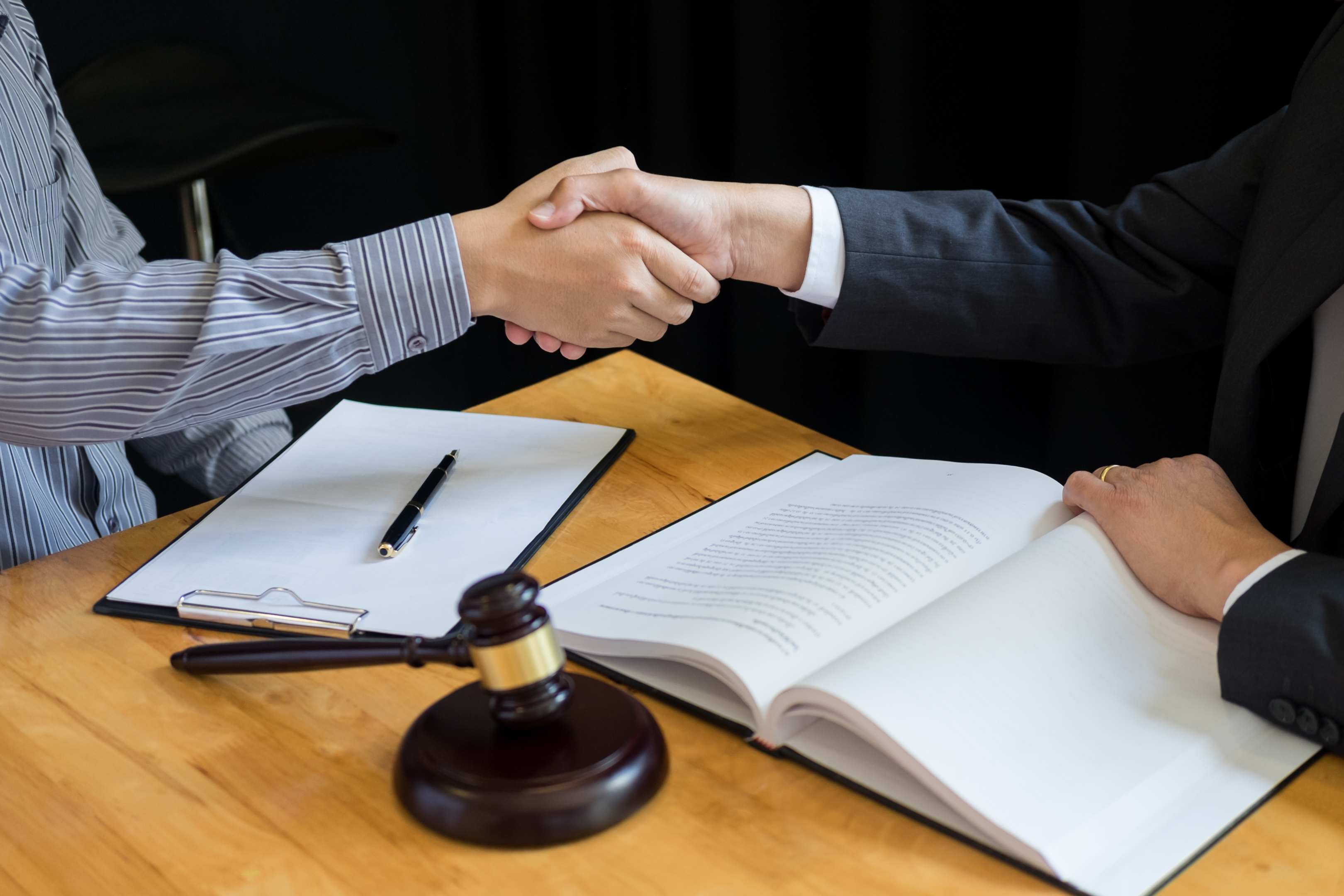  "Legal Assistance: Attorneys and clients finalize details with a handshake in the courtroom."