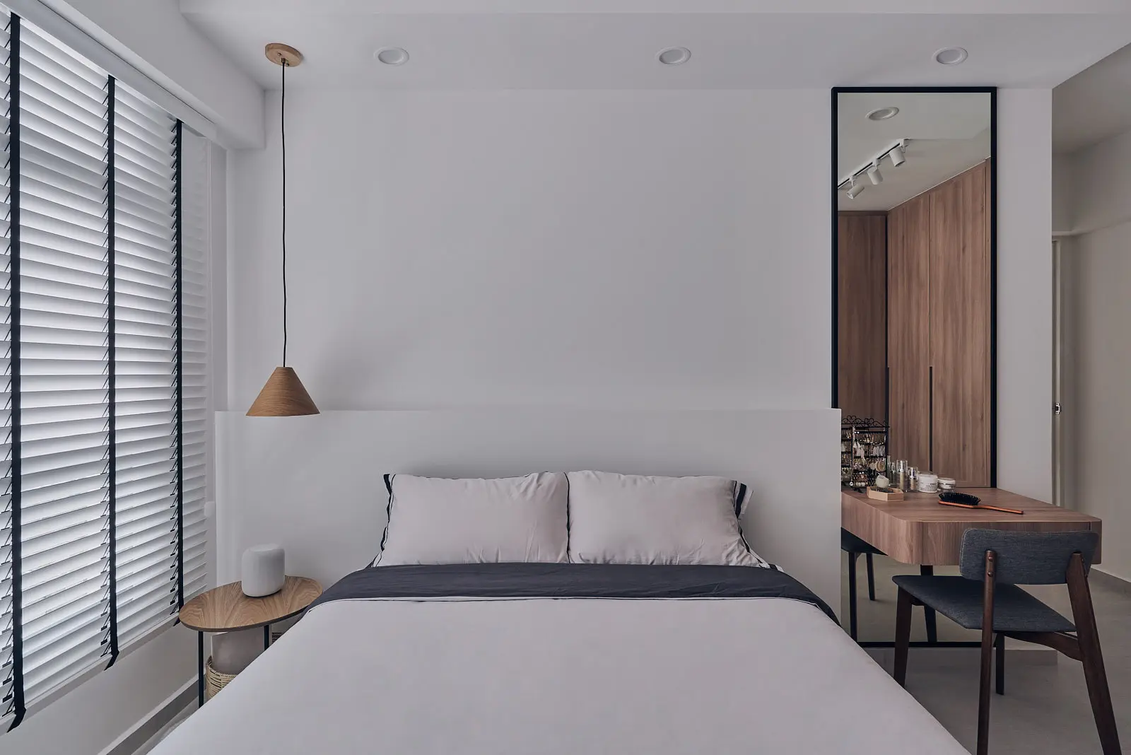 Minimalist interior design bedroom with white walls, wood vanity and pendant lamp showcasing warm neutral palette.