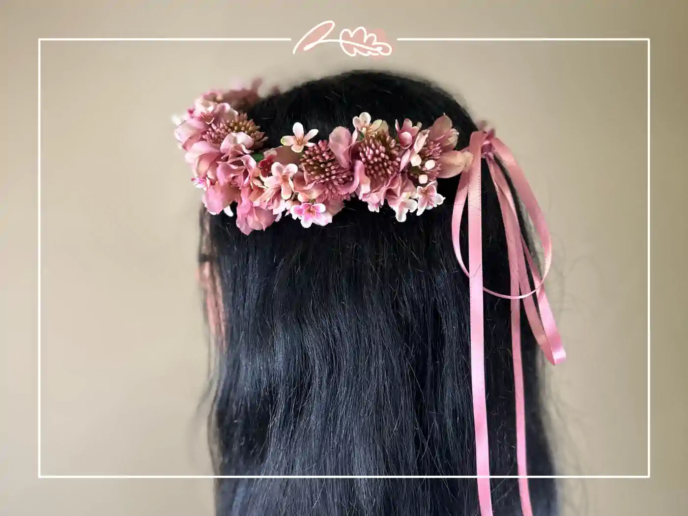 A woman with dark hair wearing a pink floral headband with ribbon accents. Rosy Enchantment Floral Crown by Fabulous Flowers and Gifts.