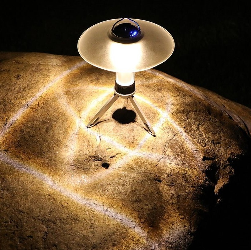 A lantern and headlamp illuminating a campsite