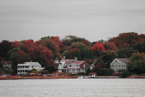 A combination of mansions along the water, steeped in fall foliage