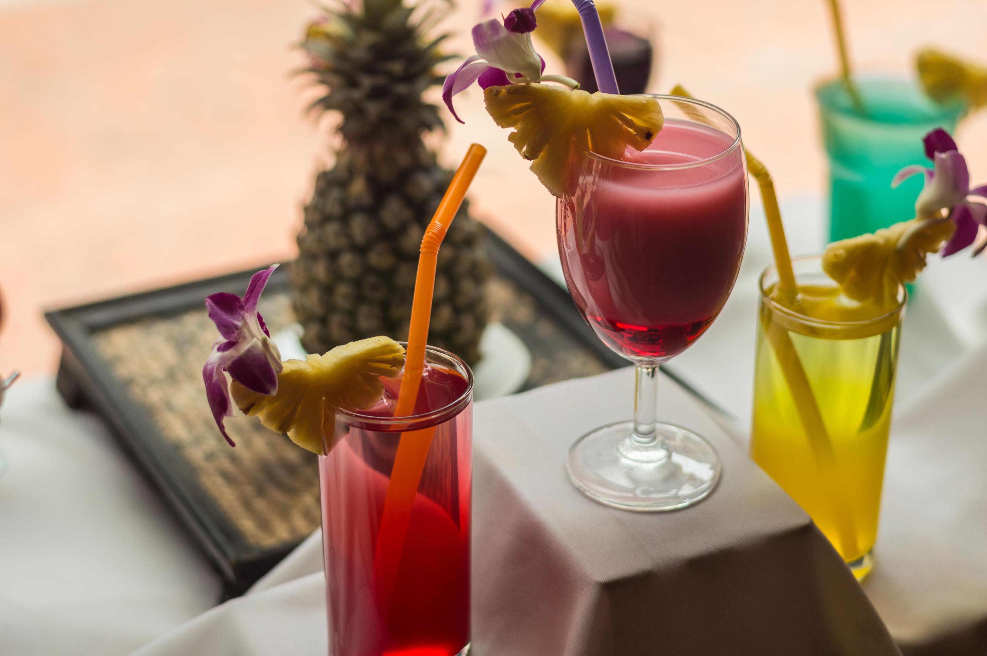 The image features a stylish bar counter adorned with an array of colorful mocktails, each beautifully garnished with fresh herbs and vibrant citrus slices, reflecting current beverage trends in the restaurant industry. This visually appealing display enhances the customer experience, showcasing the creativity and quality that many restaurants aim to deliver in their drink menus.