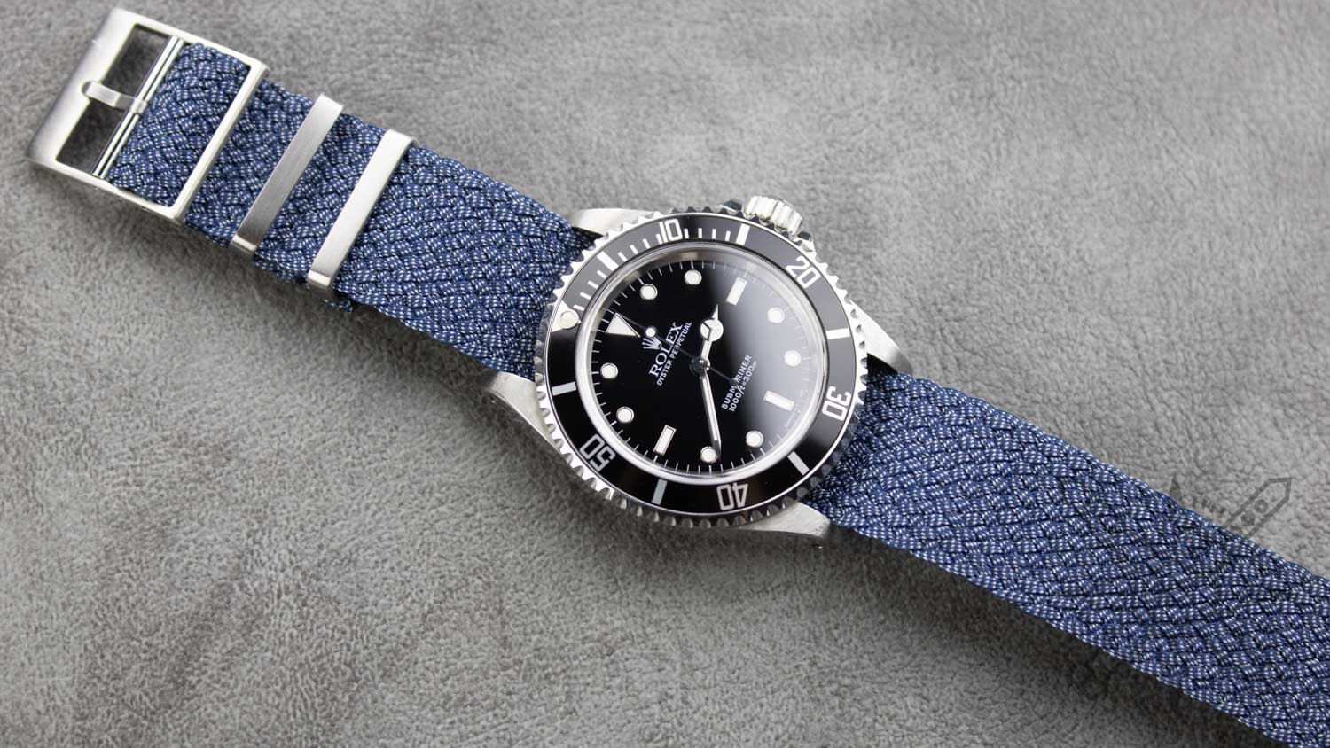 A blue perlon strap displayed against an ocean backdrop.