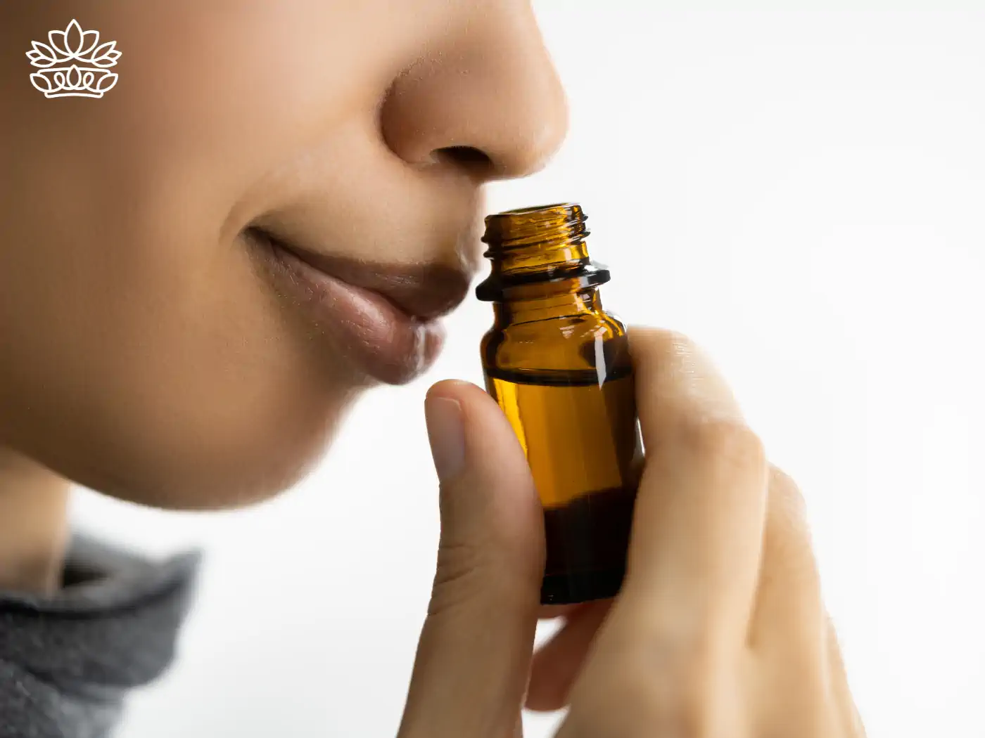 Person smelling an essential oil bottle close-up. Collection: Essential Oils, Fabulous Flowers & Gifts.