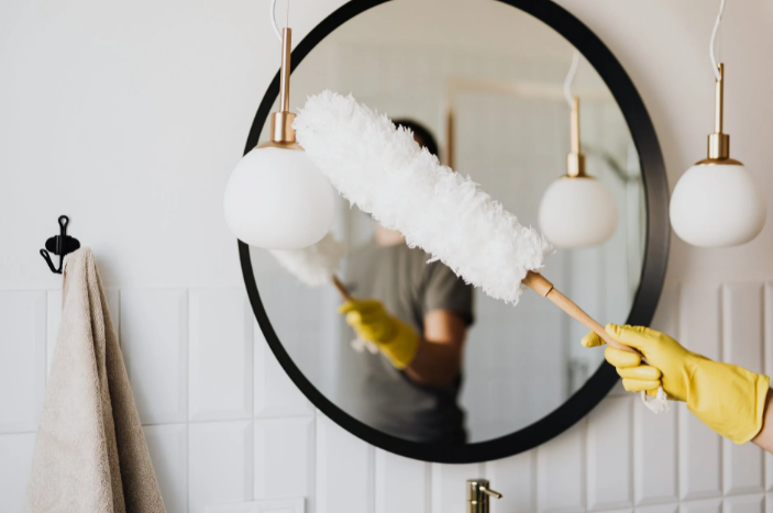 dusting a mirror during cleaning service in Tucson