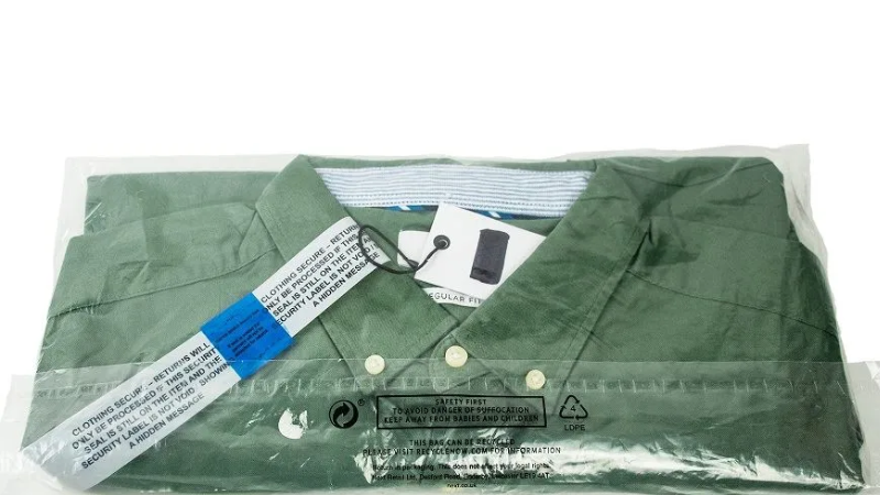 Green collared shirt with security tag, packaged in clear tamper-evident bag