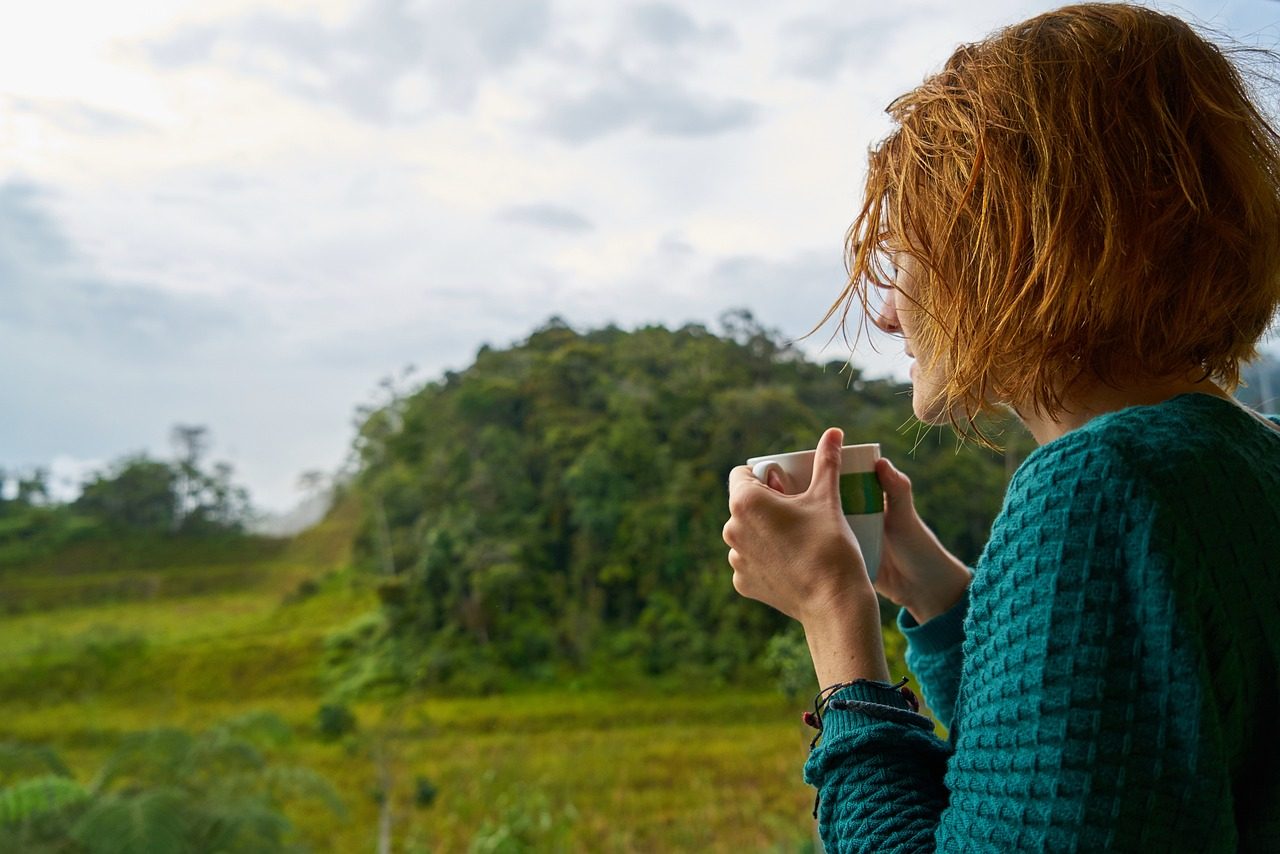 An image of a young woman drinking one of several cups of herbal teas for acid reflux.