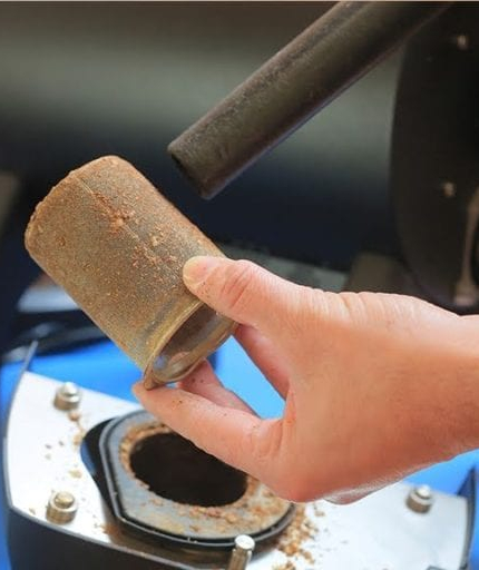 vacuuming coffee dust from a coffee roasting machine