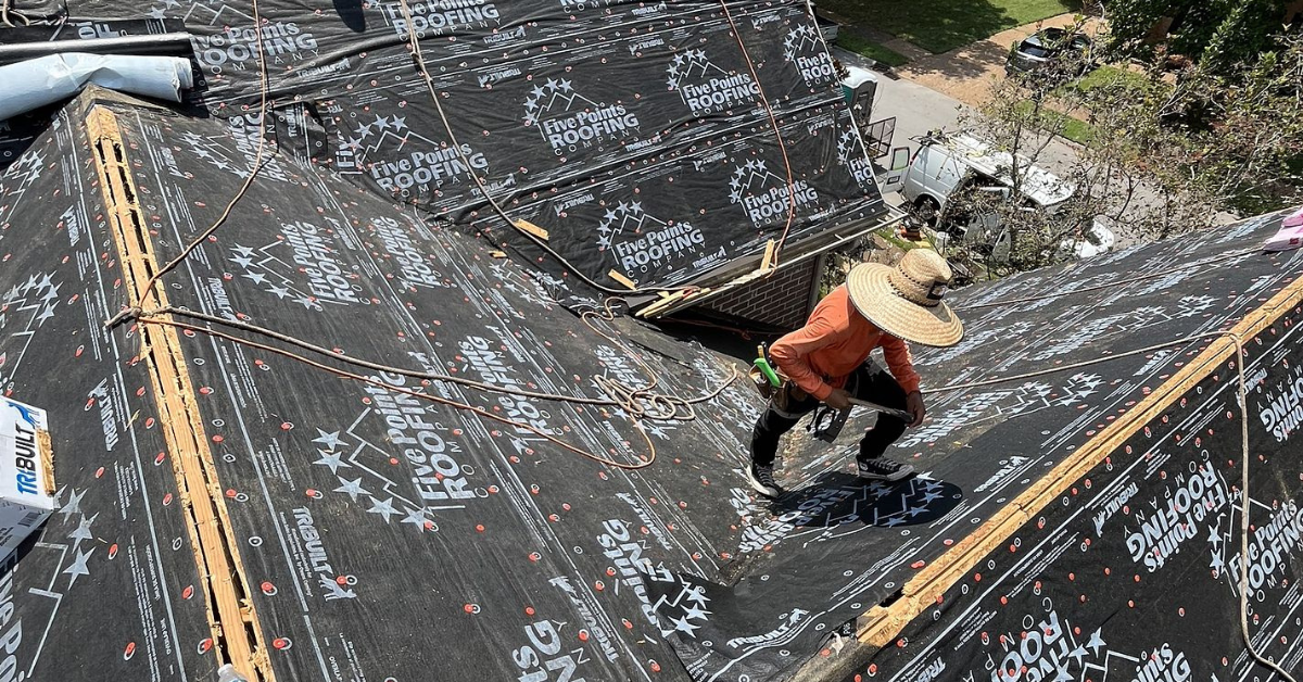 Close‑up of a roofer’s hand lifting a loose asphalt shingle during a roof inspection in Brentwood, Tennessee, identifying problem areas before repair.