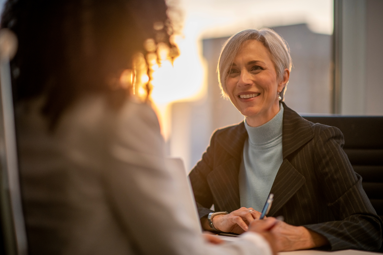 A respectful one-on-one conversation taking place in a private setting.
