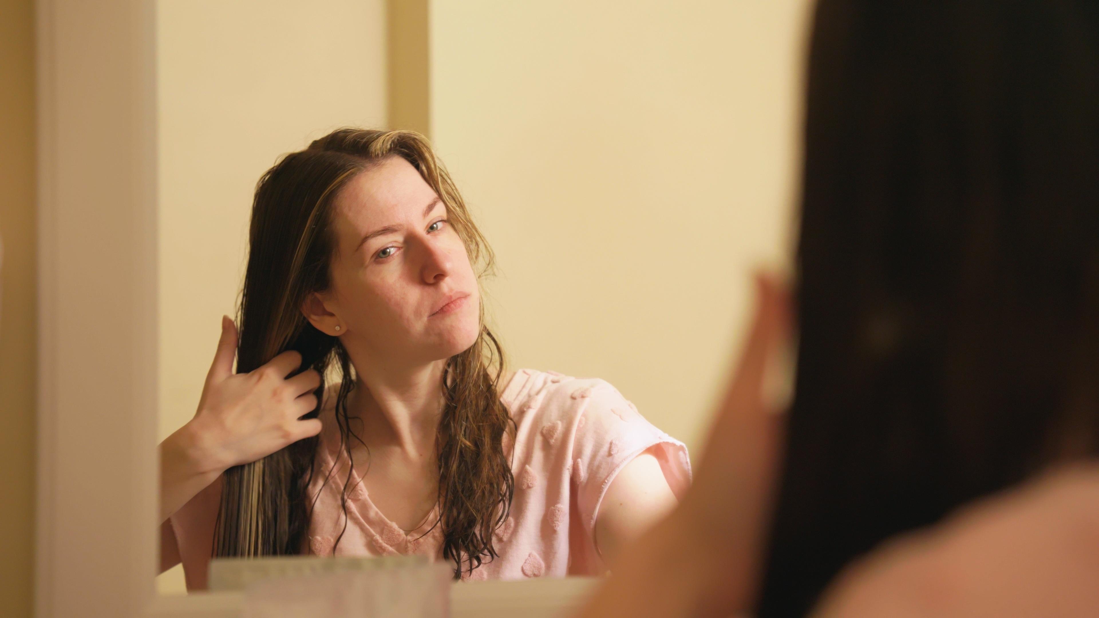 woman drying wet hair with her hands