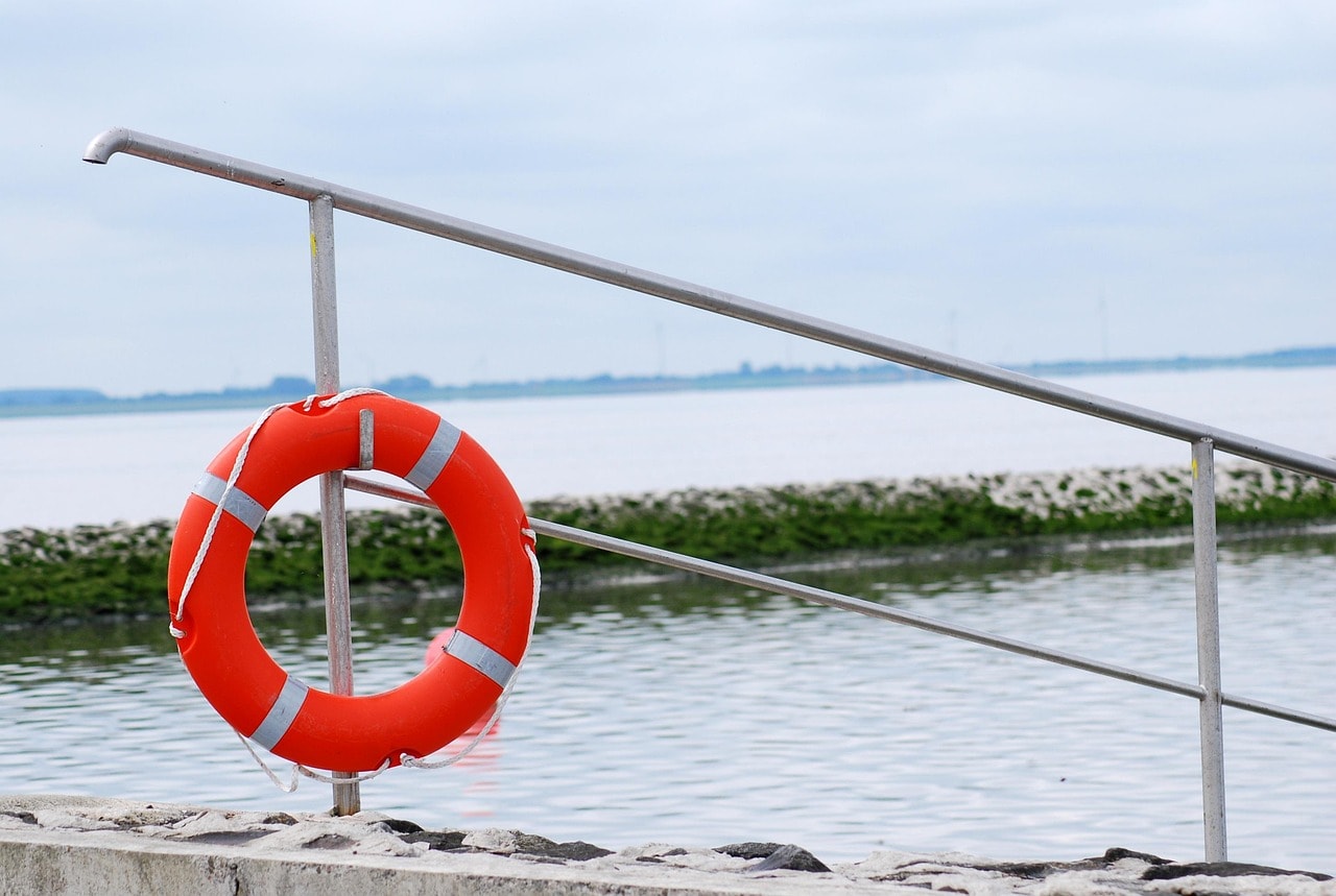 Bright coloured life buoy on a sea dock.