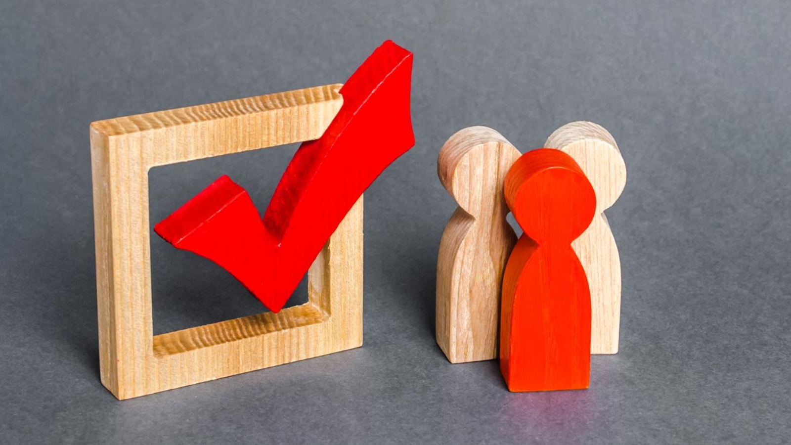 Wooden figures beside a bold red check mark, illustrating how the right partner aligns marketing tactics with business objectives.