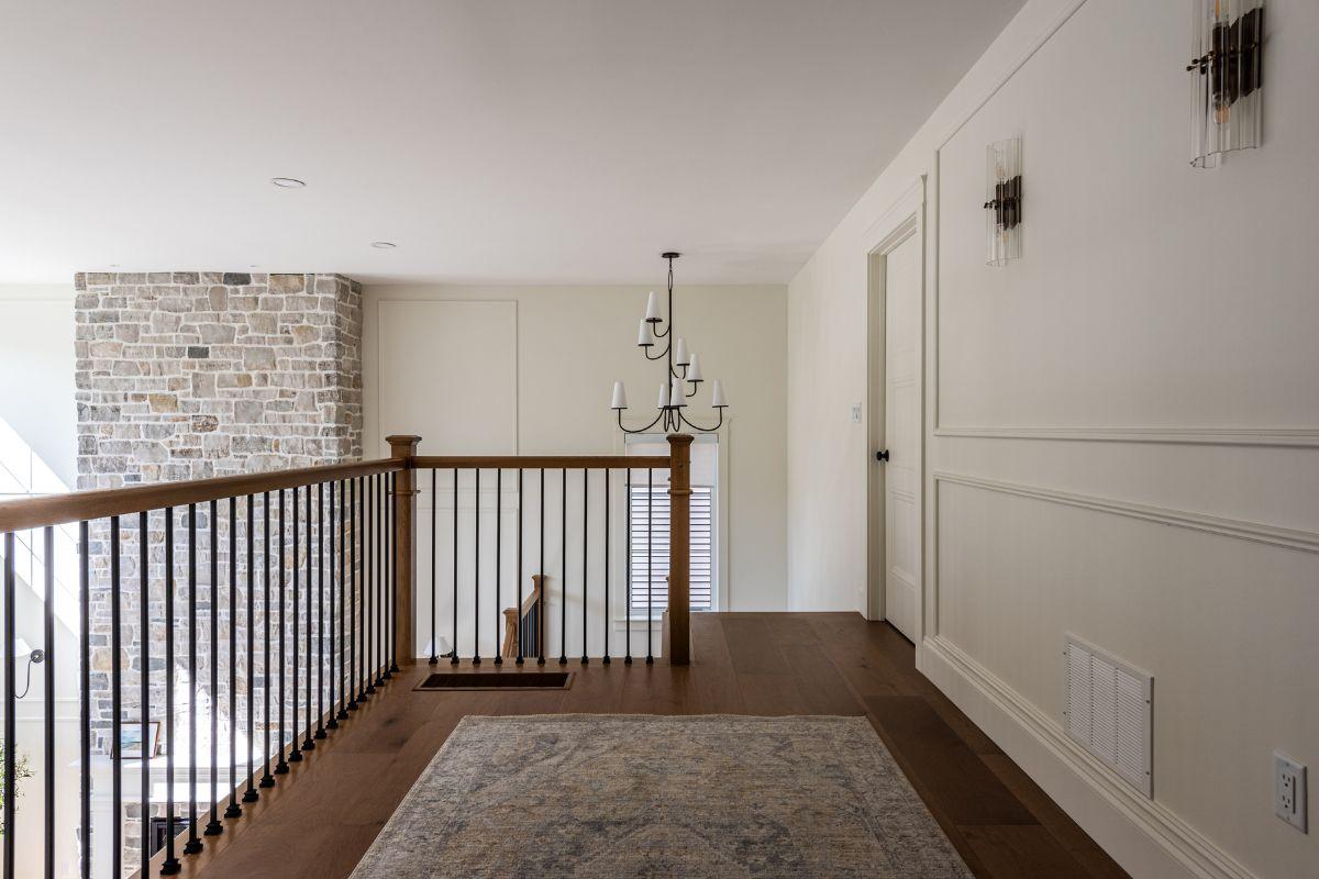 Staircase landing with chandelier sized for ceiling height, showing proper scale in open space