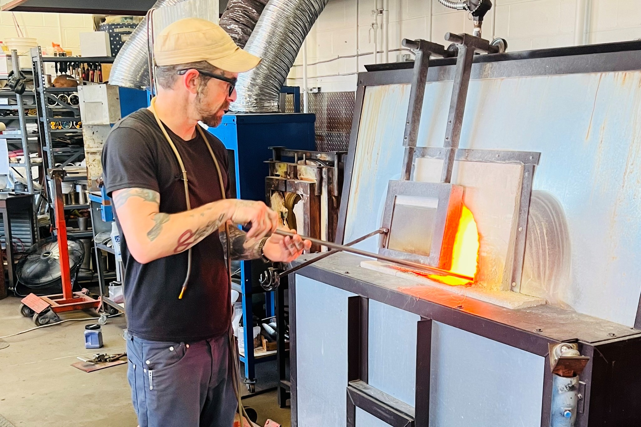 A man creating a glass artwork at The Furnace 