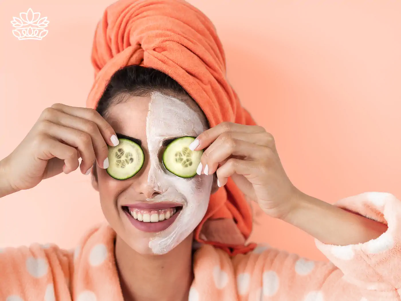 Woman with an orange towel and a face mask holding cucumber slices over her eyes, showing a fun and relaxing beauty routine. Fabulous Flowers and Gifts.