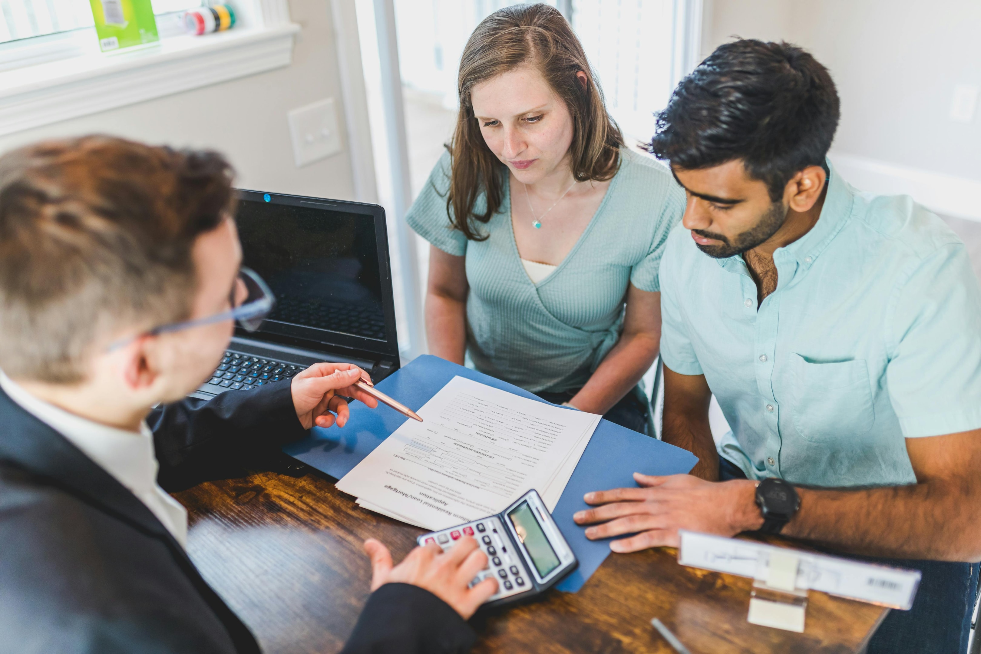 Recent beneficiaries meet with real estate agent to discuss terms of selling their home. 