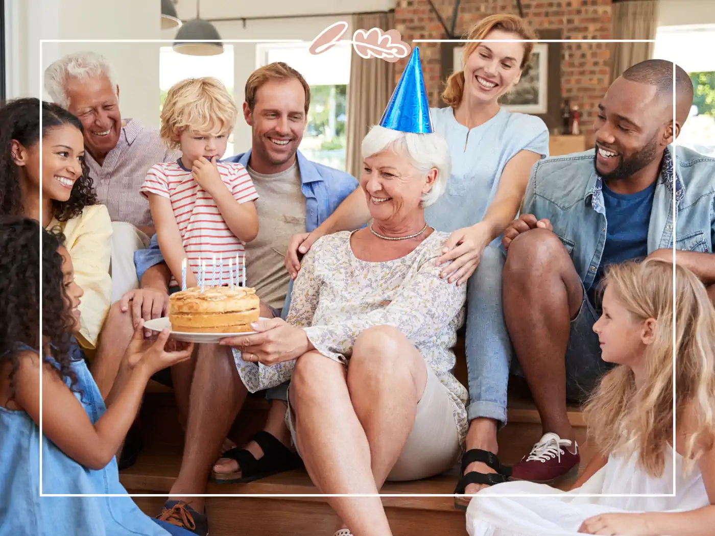 A multigenerational family celebrating a birthday, with a grandmother holding a cake. Fabulous Flowers and Gifts.