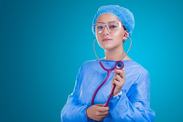 An image of a young female doctor in blue surgical scrubs and a stethoscope.