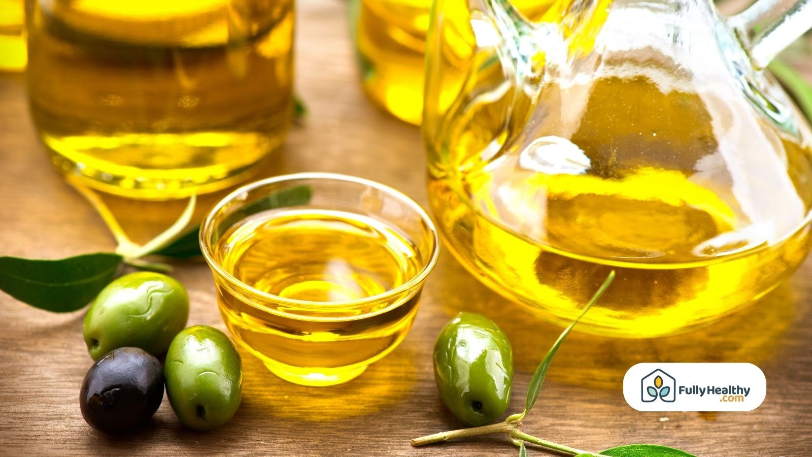 Glass jugs and bowls of extra virgin olive oil with fresh olives