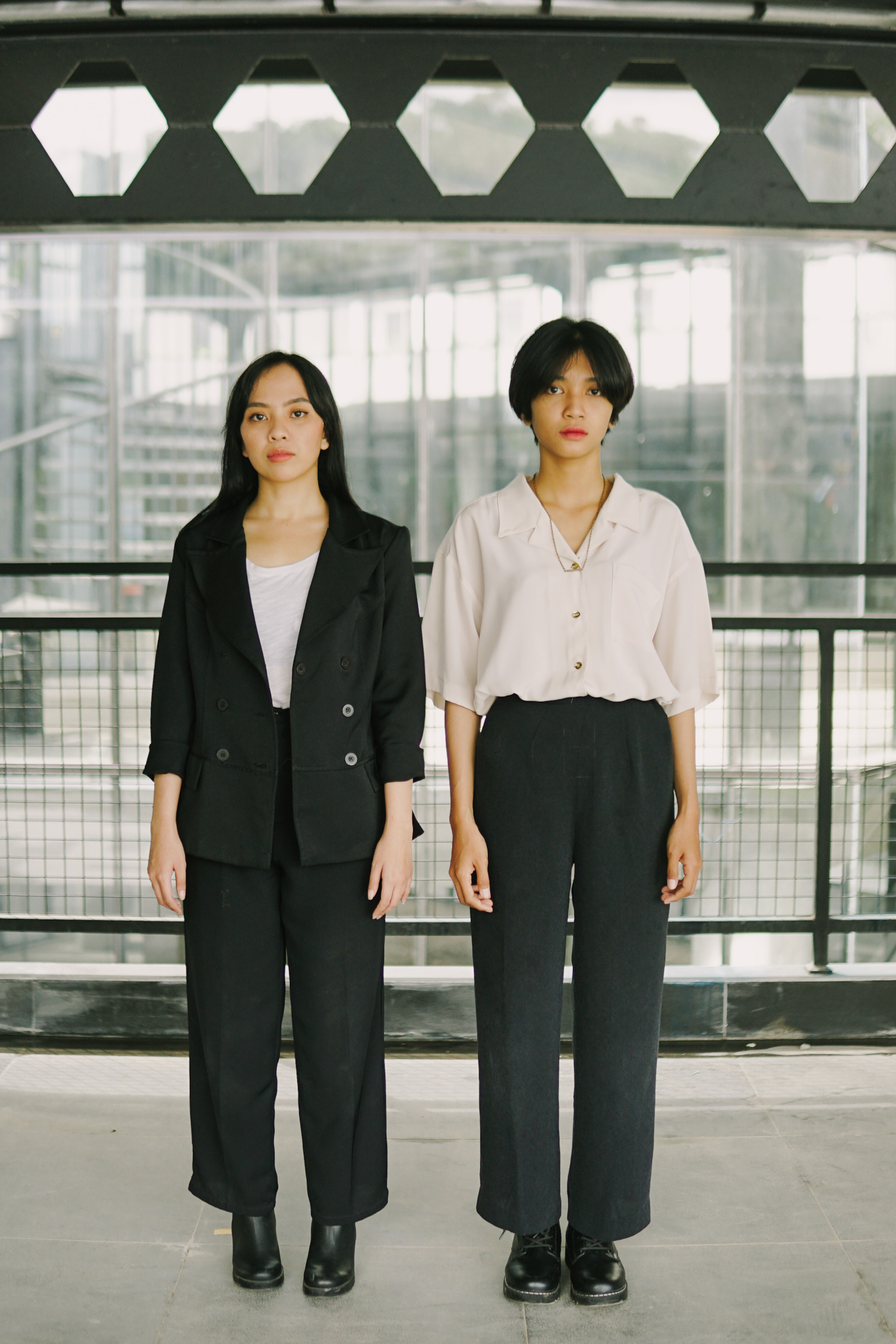 Two Young Women Wearing Basic Office Outfits Standing Side by Side