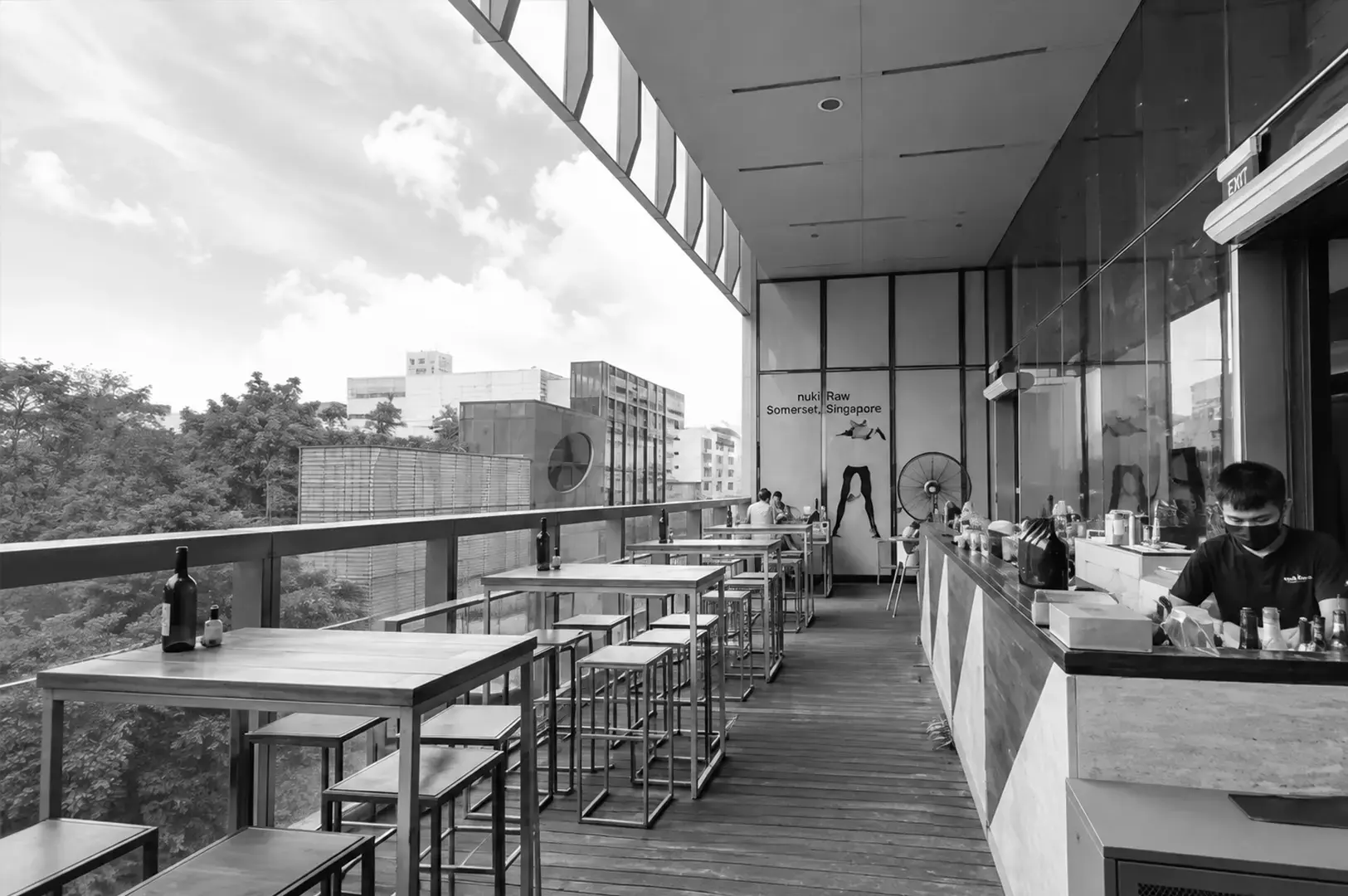 utdoor dining terrace at Tanuki Raw Orchard Central with bar seating, city views, and a relaxed atmosphere.