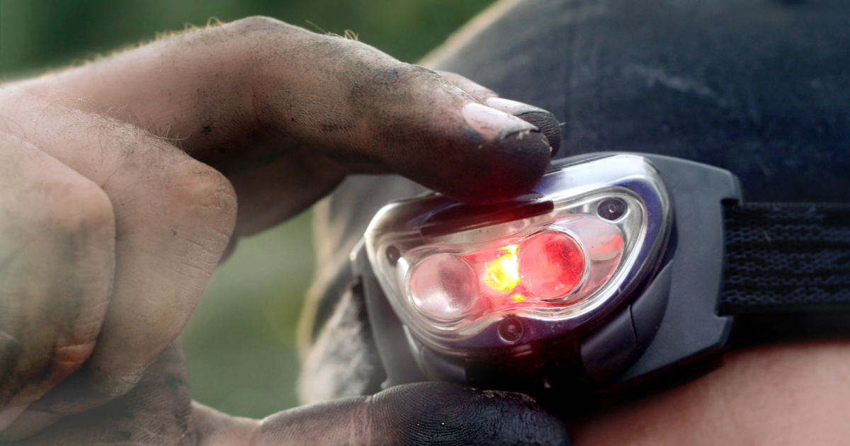 Close-up of fingers turning on a headlamp - Adventure Wise Travel Gear