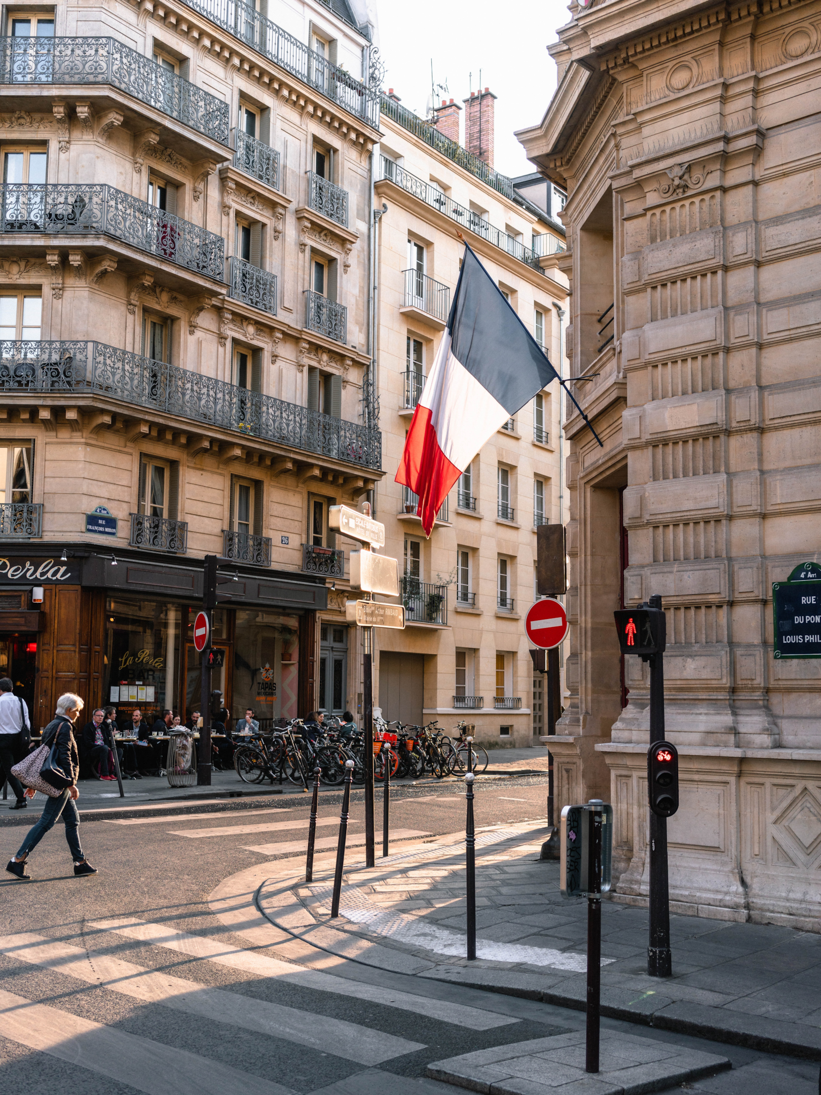 French flag at a street intersection in France with French architecture