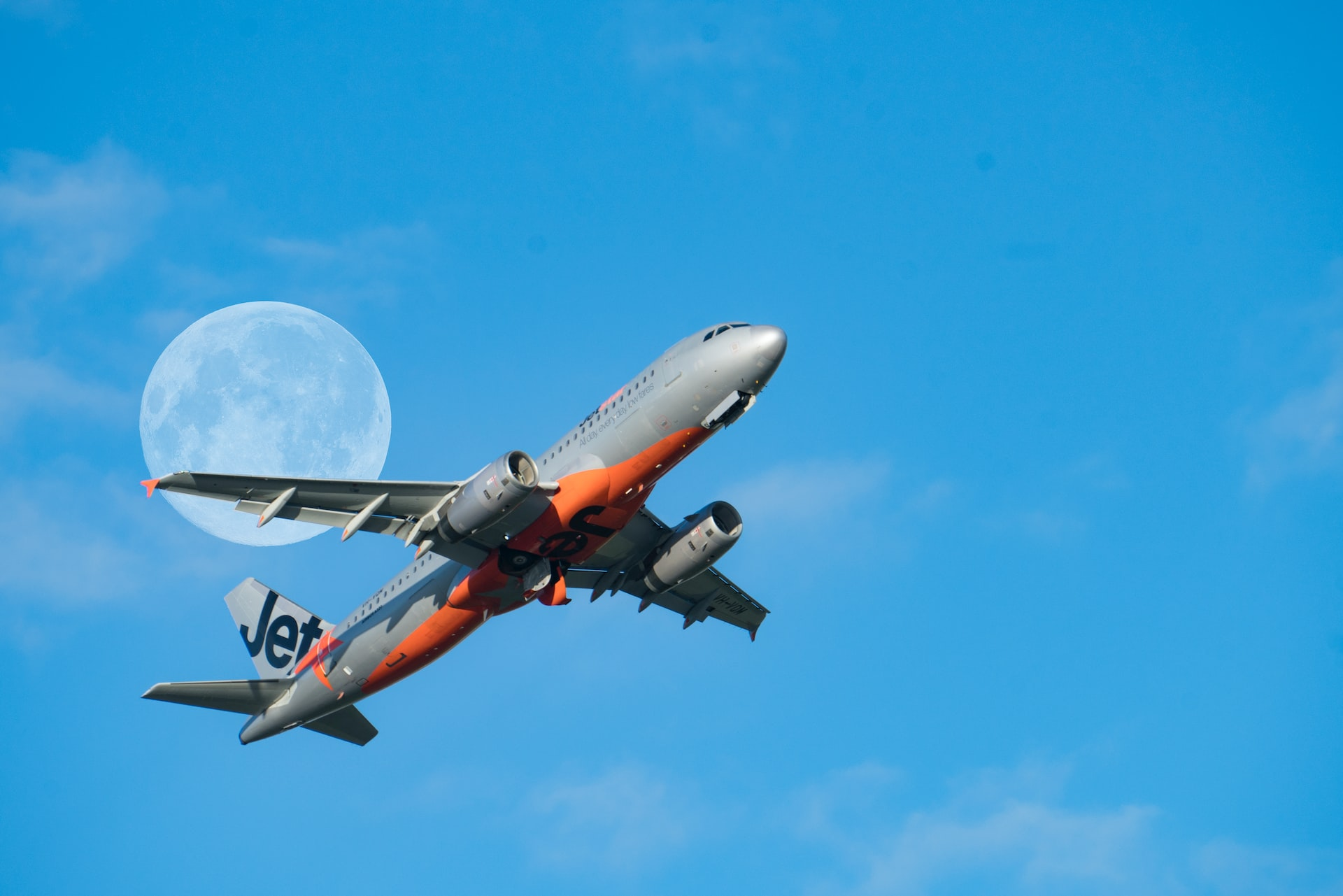 An aircraft taking off with a moon in the background.
