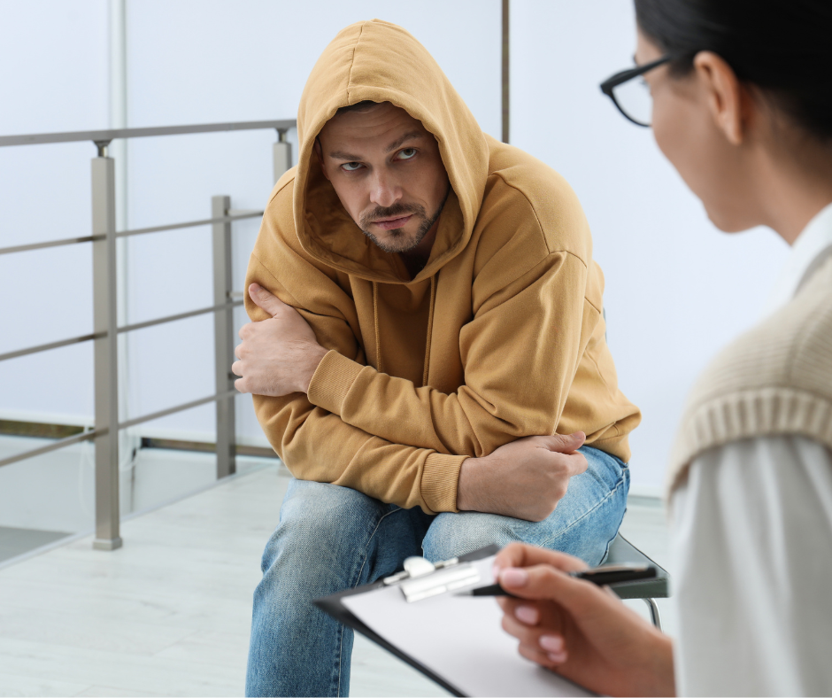 A person struggling with alcohol addiction, receiving help from a professional