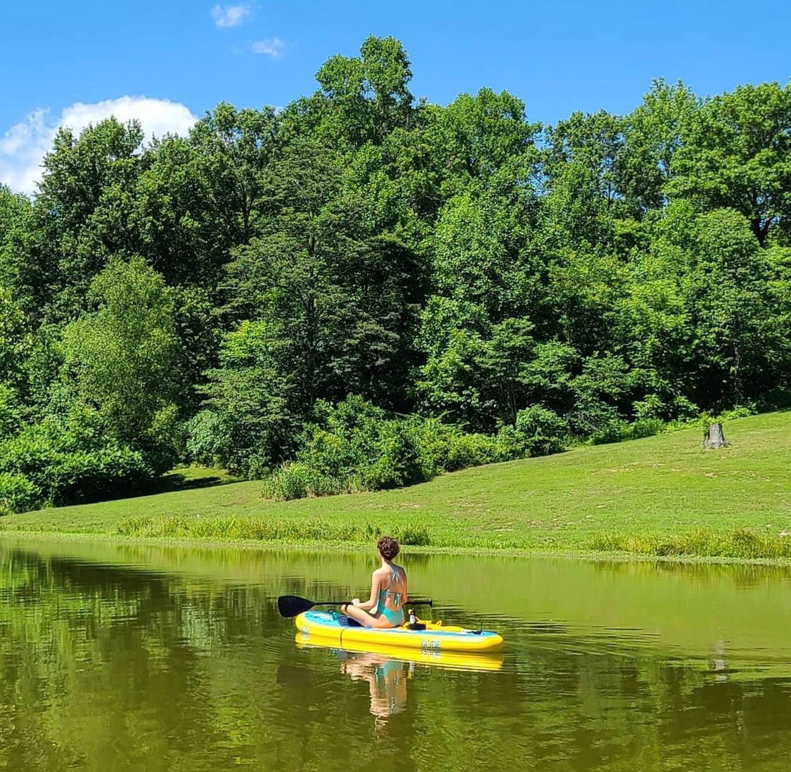 woman sitting on an inflatable paddle board