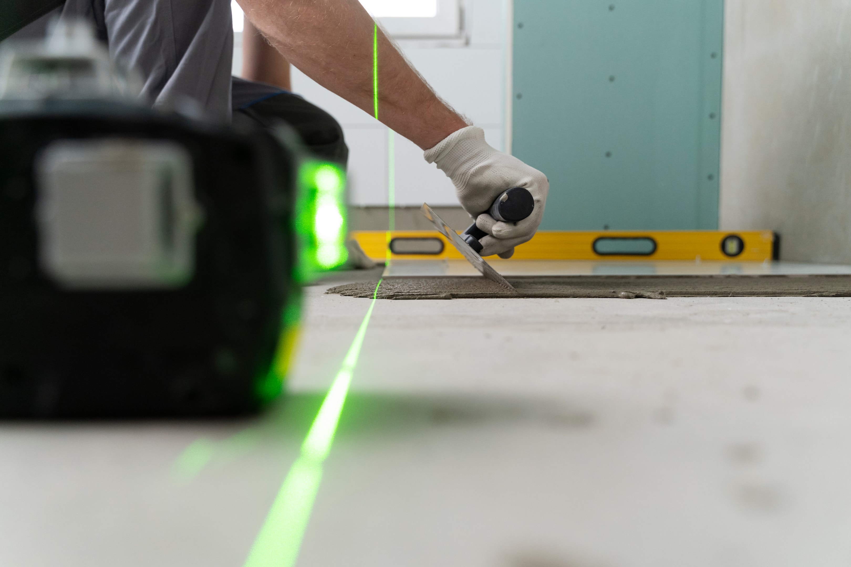 a man using a laser measure to apply cement accurately
