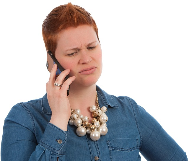 An image of a woman on the phone protecting her voice. 