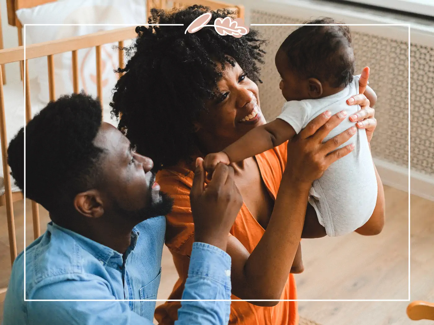 A joyful family holding their baby, with both parents looking lovingly at their child. Fabulous Flowers and Gifts.