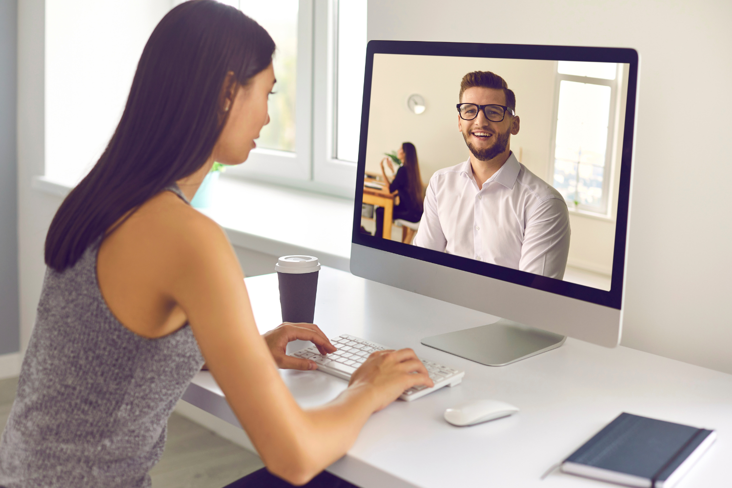 A Filipino worker interacting with a Western manager through a video call.