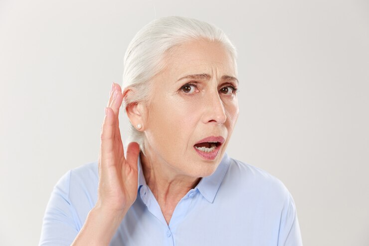 Senior woman holding her ear struggling to hear a sound