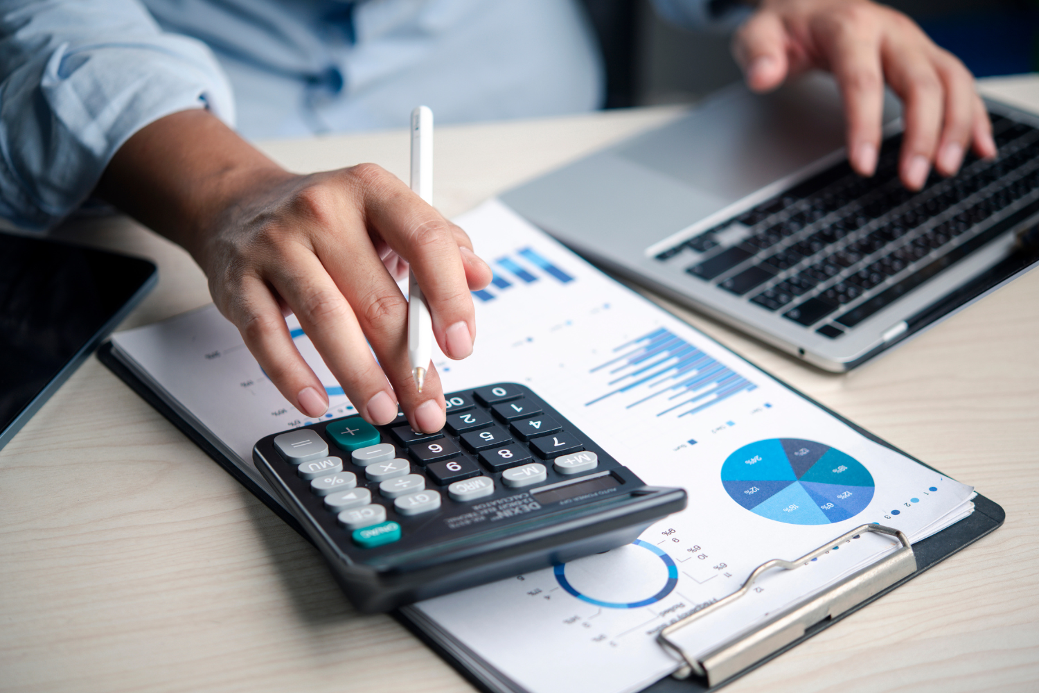 A person using a calculator on a desk.