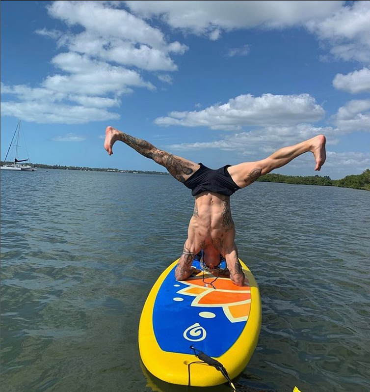 Hand stand while paddle boarding the Glide Lotus yoga sup. No paddle holder needed.