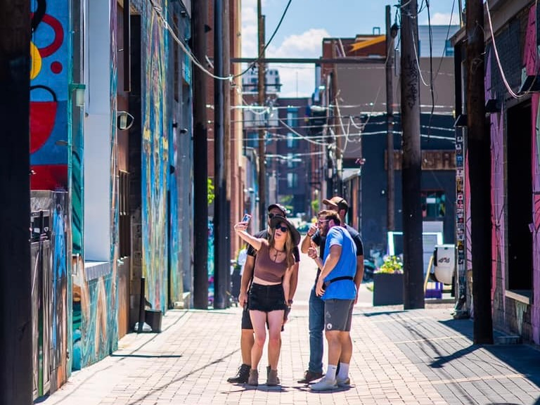 A group snapping a selfie while on a Let's Roam scavenger hunt in RiNo, Denver