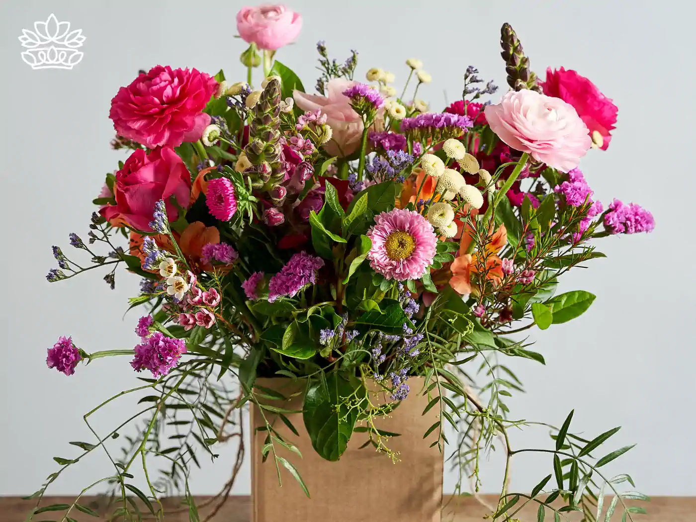 Vibrant get well bouquet in a rustic brown paper bag, brimming with pink roses, magenta blooms, and assorted fresh greenery, crafted to uplift spirits. Delivered with Heart. Fabulous Flowers and Gifts.