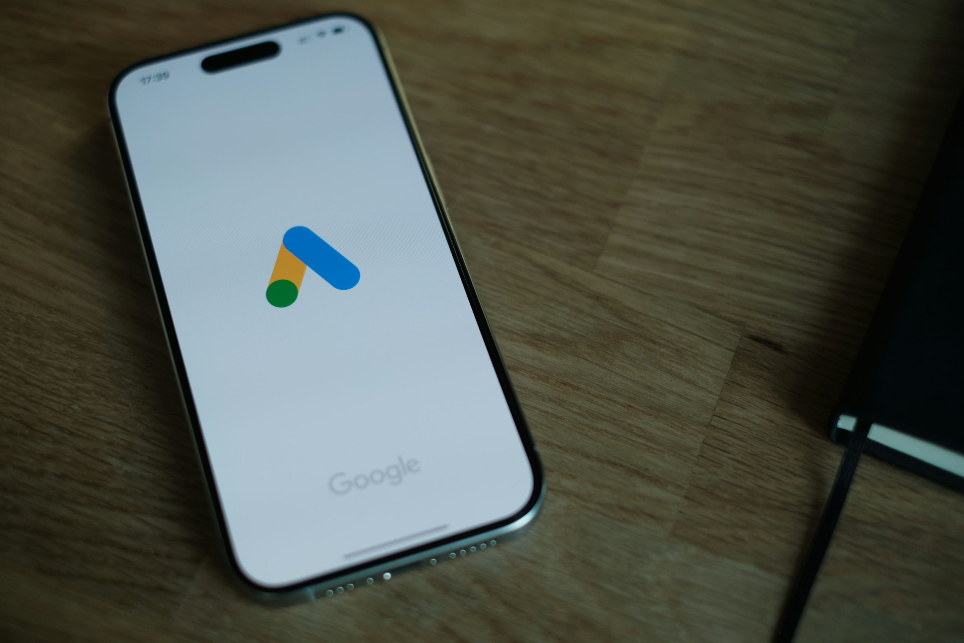 Smartphone showing google ads logo, used by real estate investor to help promote their investment business. 